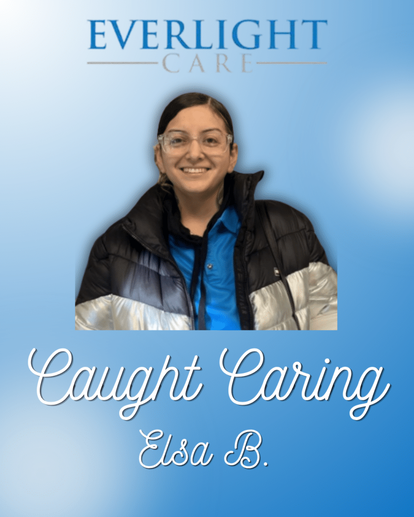 Portrait of Elsa B. smiling in a blue jacket, featured in a 'Caught Caring' recognition by Everlight Care against a blue gradient background with logo above